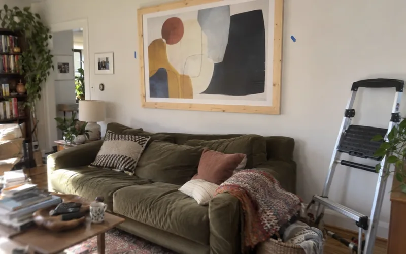 Large homemade wood frame with an art print hung above a sofa