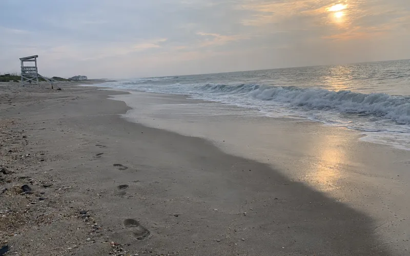 Quiet public beach early on a weekday morning with gentle waves
